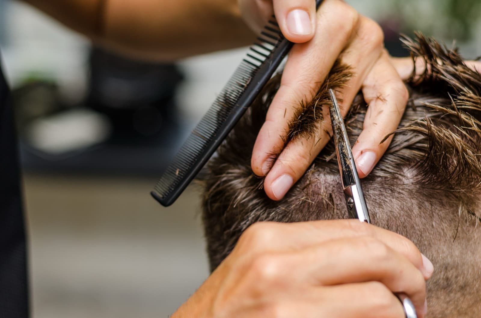 Barber cutting hair with freshly sharpened scissors